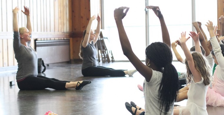 Ballet students stretch on the floor during Synapse Arts ballet class at Loyola Park